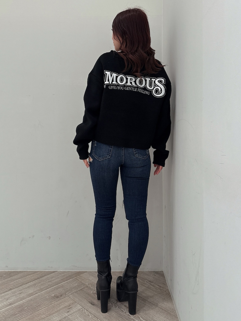 ブラック系のニット/セーター、ブルー系のデニムパンツ、ブラック系のブーツを着用したレディースの秋コーディネートの3枚目の写真