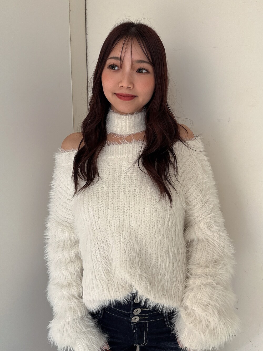 ホワイト系のニット/セーター、ブルー系のデニムパンツ、ホワイト系のパンプスを着用したレディースの秋コーディネートの4枚目の写真