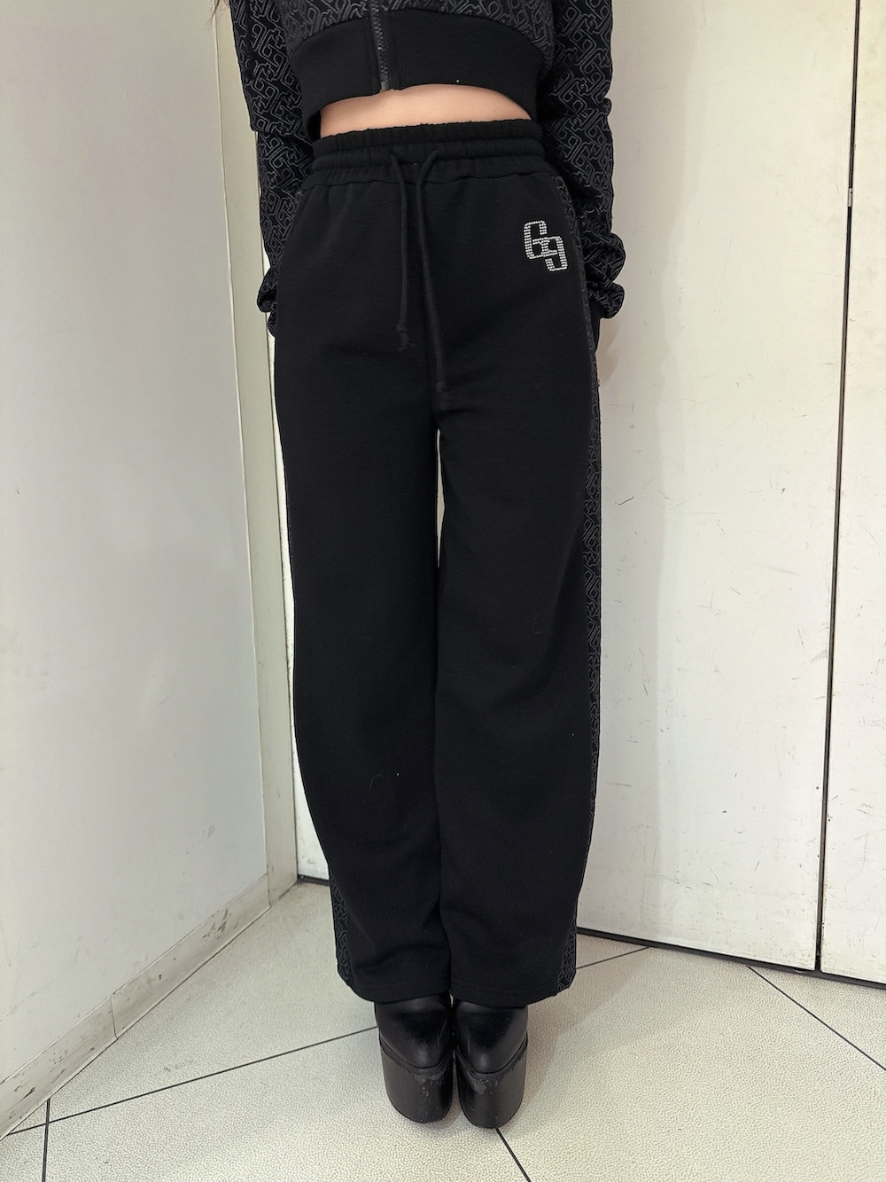 ブラック系のスウェットパンツ、ブラック系のパーカー、ブラック系のブーツを着用したレディースの冬コーディネートの8枚目の写真