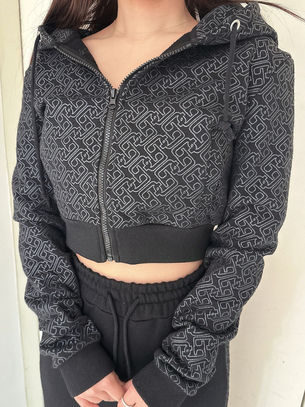 ブラック系のデニムパンツ、ブラック系のパーカー、ブラック系のブーツを着用したレディースの冬コーディネートの7枚目の写真