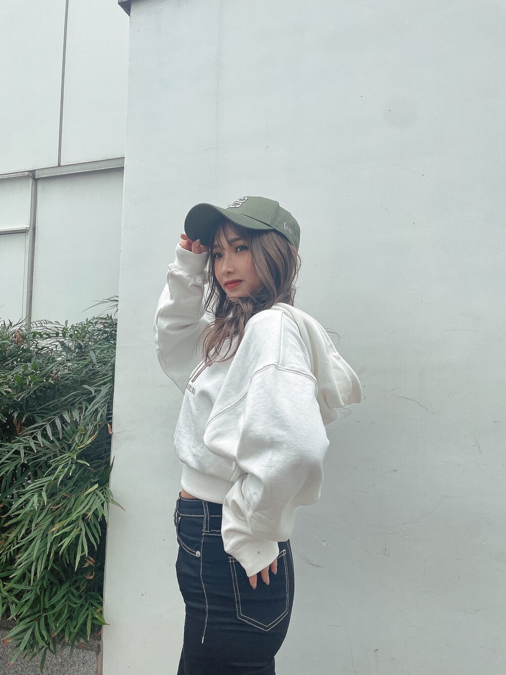 ホワイト系のパーカー、ブラック系のデニムパンツ、ブラック系のブーツを着用したレディースの冬コーディネートの4枚目の写真