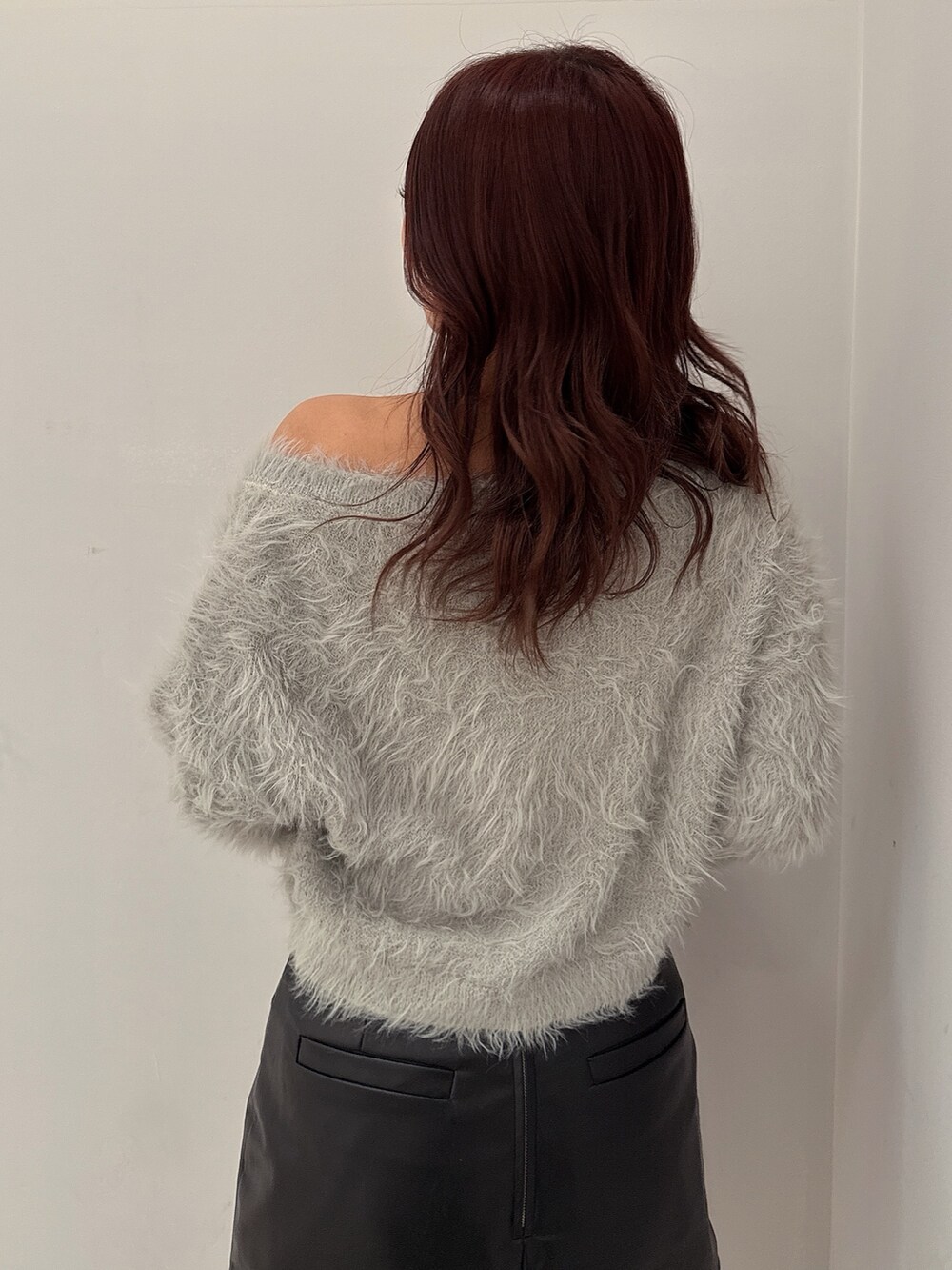 ブラック系のブーツ、ブラック系のスカート、ホワイト系のハンドバッグを着用したレディースの冬コーディネートの6枚目の写真