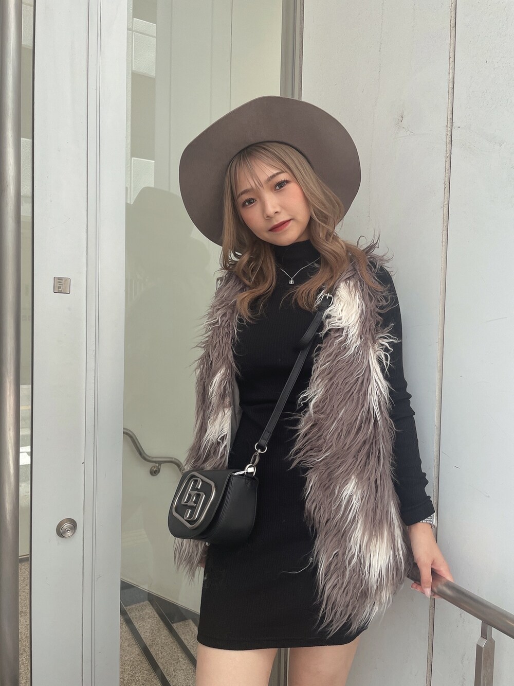 ブラック系のワンピース、その他のベスト、ブラック系のハンドバッグを着用したレディースの秋コーディネートの4枚目の写真