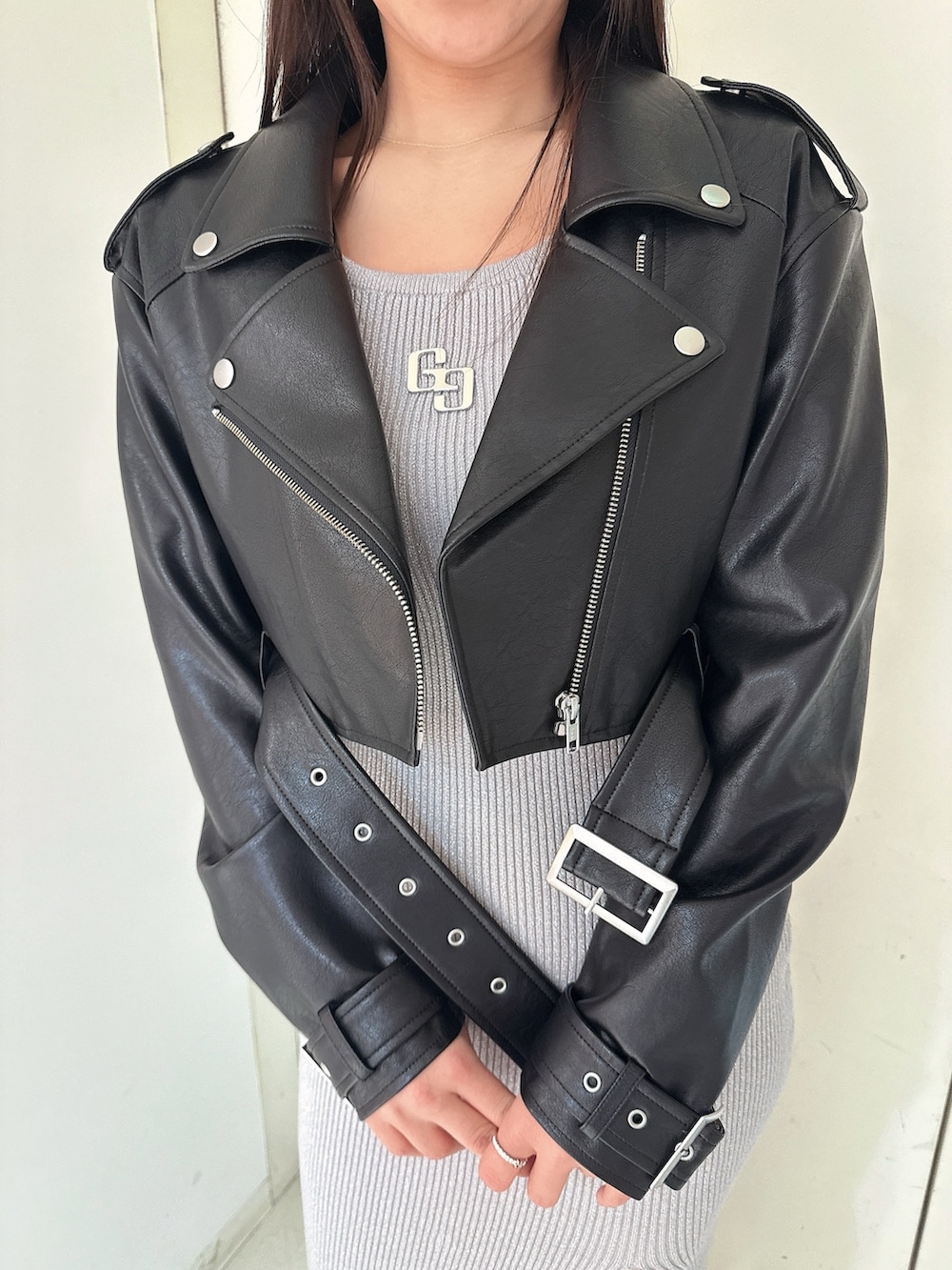 シルバー系のワンピース、ブラック系のライダースジャケット、ブラック系のブーツを着用したレディースの冬コーディネートの7枚目の写真