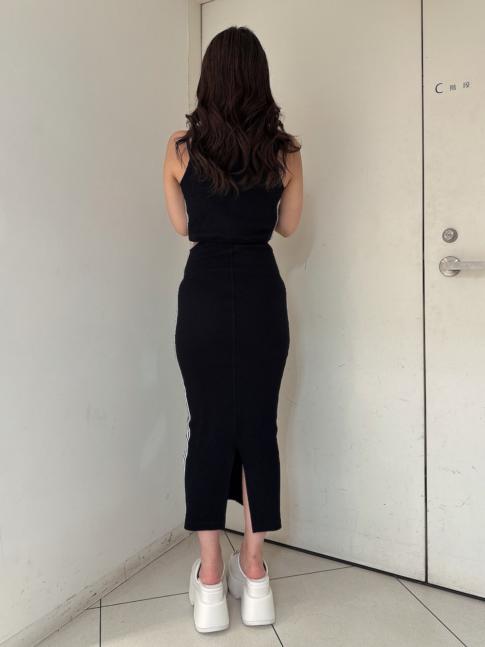 ブラック系のワンピース、ホワイト系のサンダルを着用したレディースの夏コーディネートの3枚目の写真