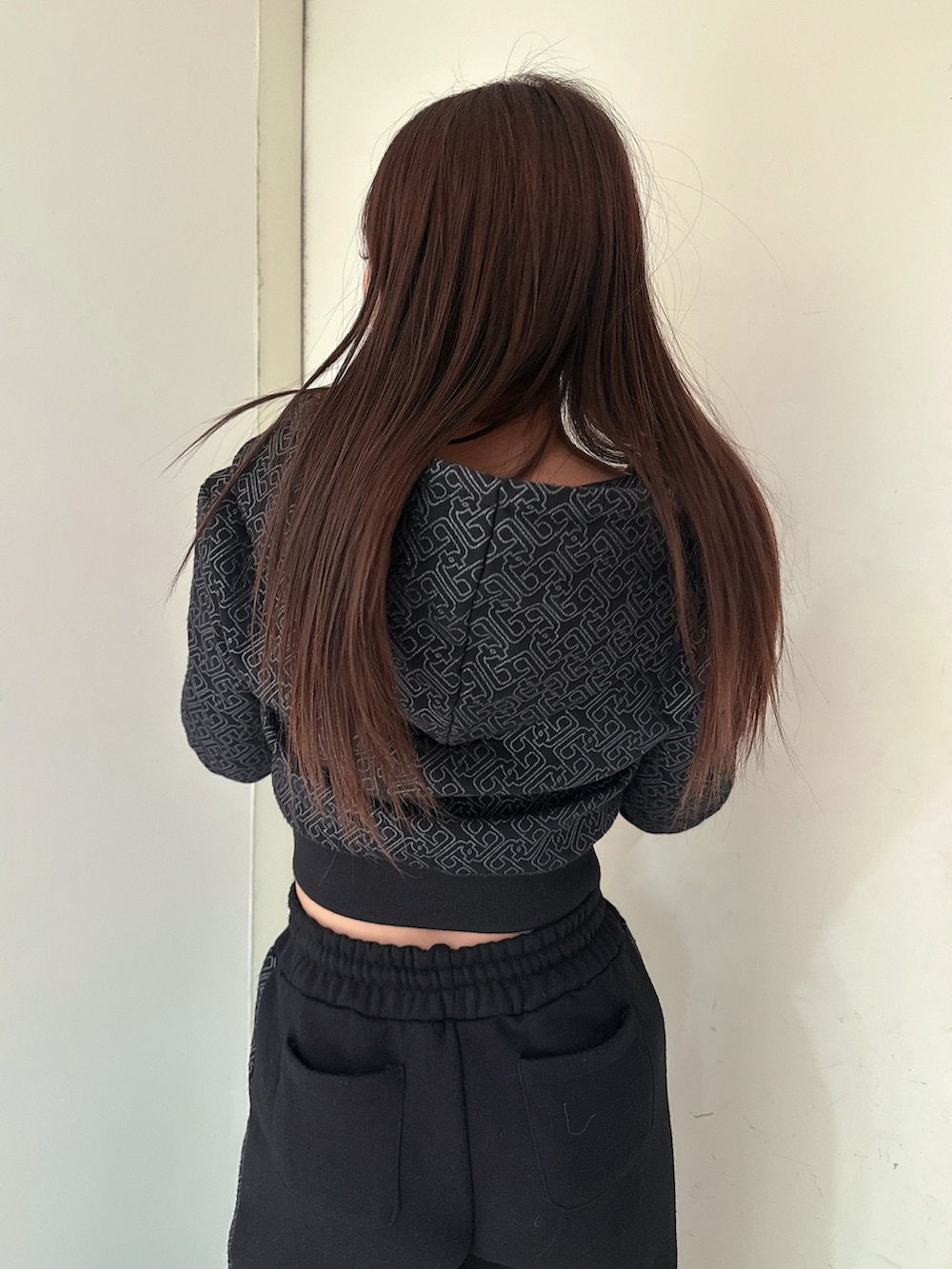 ブラック系のスウェットパンツ、ブラック系のパーカー、ブラック系のブーツを着用したレディースの冬コーディネートの6枚目の写真