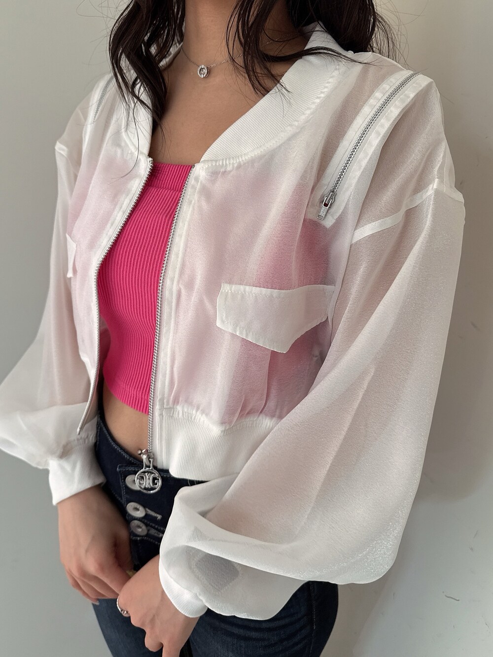 ブルー系のデニムパンツ、ホワイト系のブルゾン、ピンク系のキャミソールを着用したレディースの春コーディネートの7枚目の写真