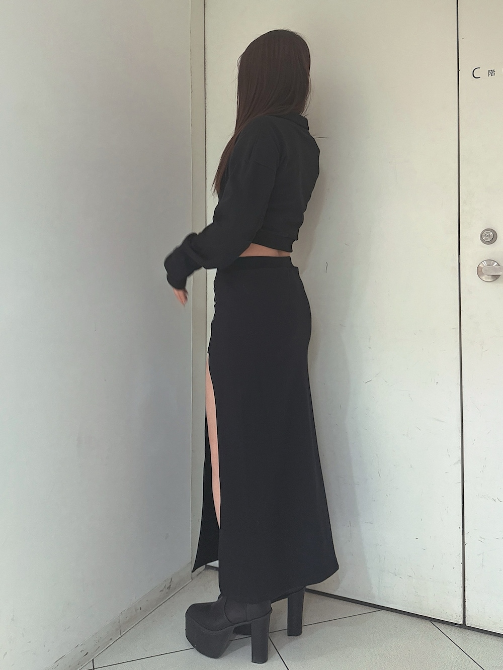 ブラック系のスウェット、ブラック系のスカートを着用したレディースの冬コーディネートの2枚目の写真