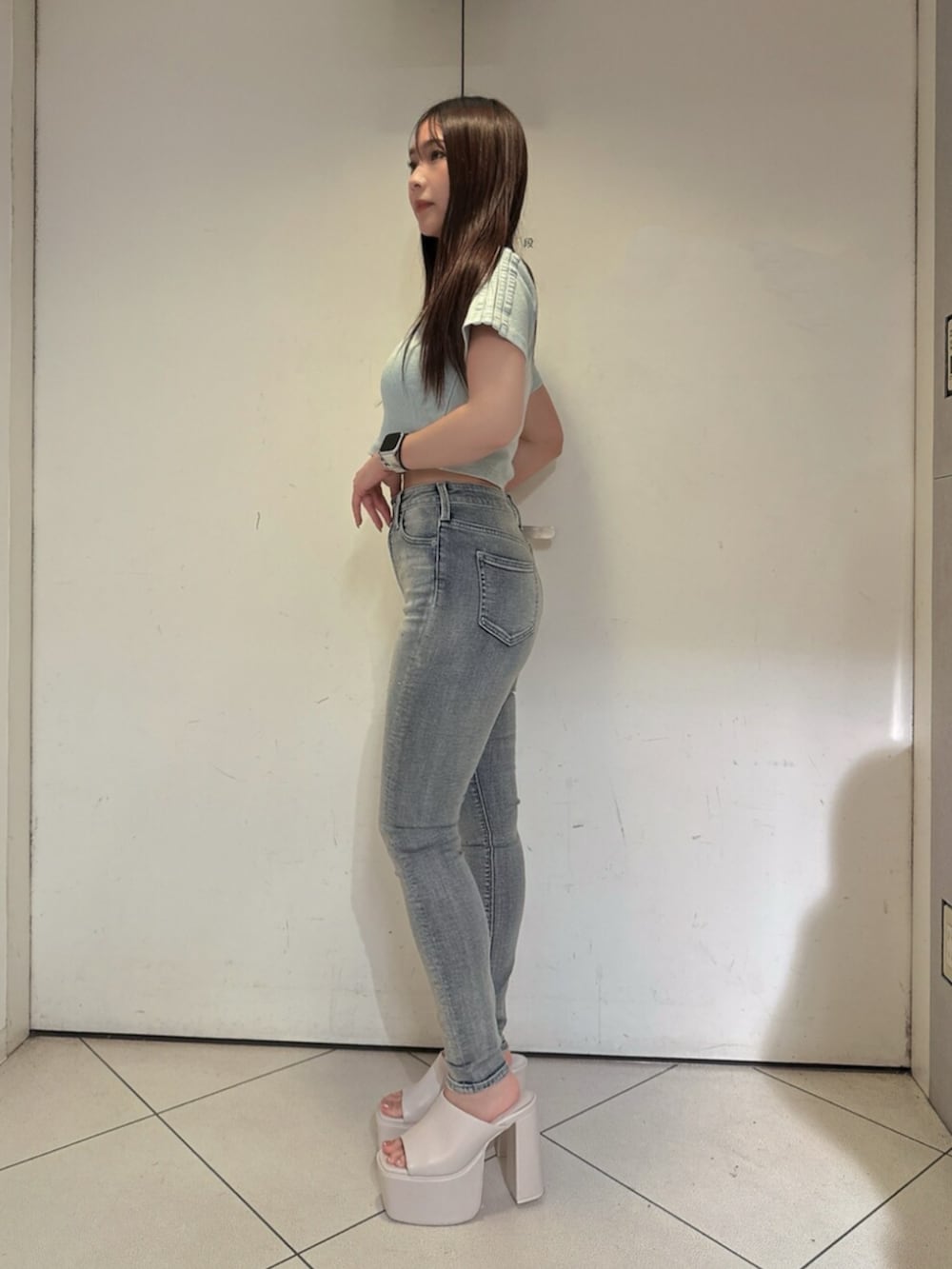ホワイト系のサンダル、ブルー系のデニムパンツ、ブルー系のTシャツ/カットソーを着用したレディースの夏コーディネートの2枚目の写真