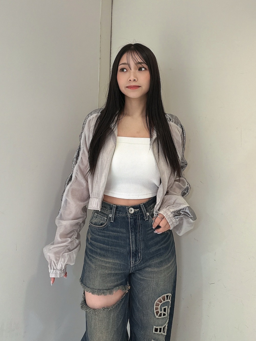 ブルー系のデニムパンツ、ホワイト系のキャミソール、ホワイト系のブルゾンを着用したレディースの春コーディネートの4枚目の写真