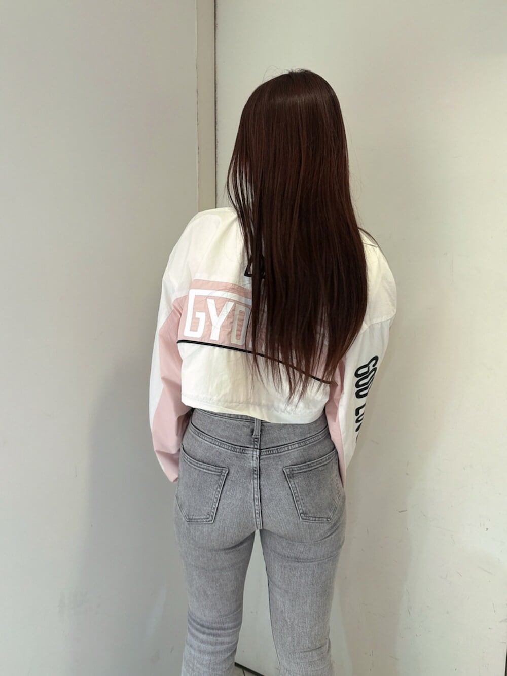 グレー系のデニムパンツ、ホワイト系のTシャツ/カットソー、ブラック系のブーツを着用したレディースの夏コーディネートの6枚目の写真