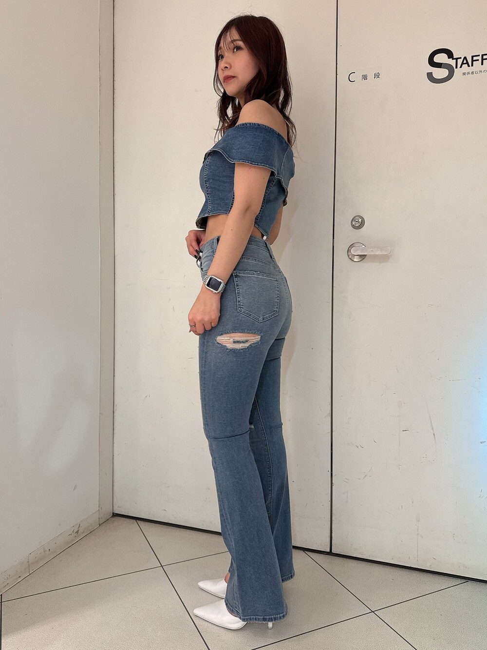 ブルー系のTシャツ/カットソー、ブルー系のデニムパンツ、ホワイト系のパンプスを着用したレディースの冬コーディネートの2枚目の写真
