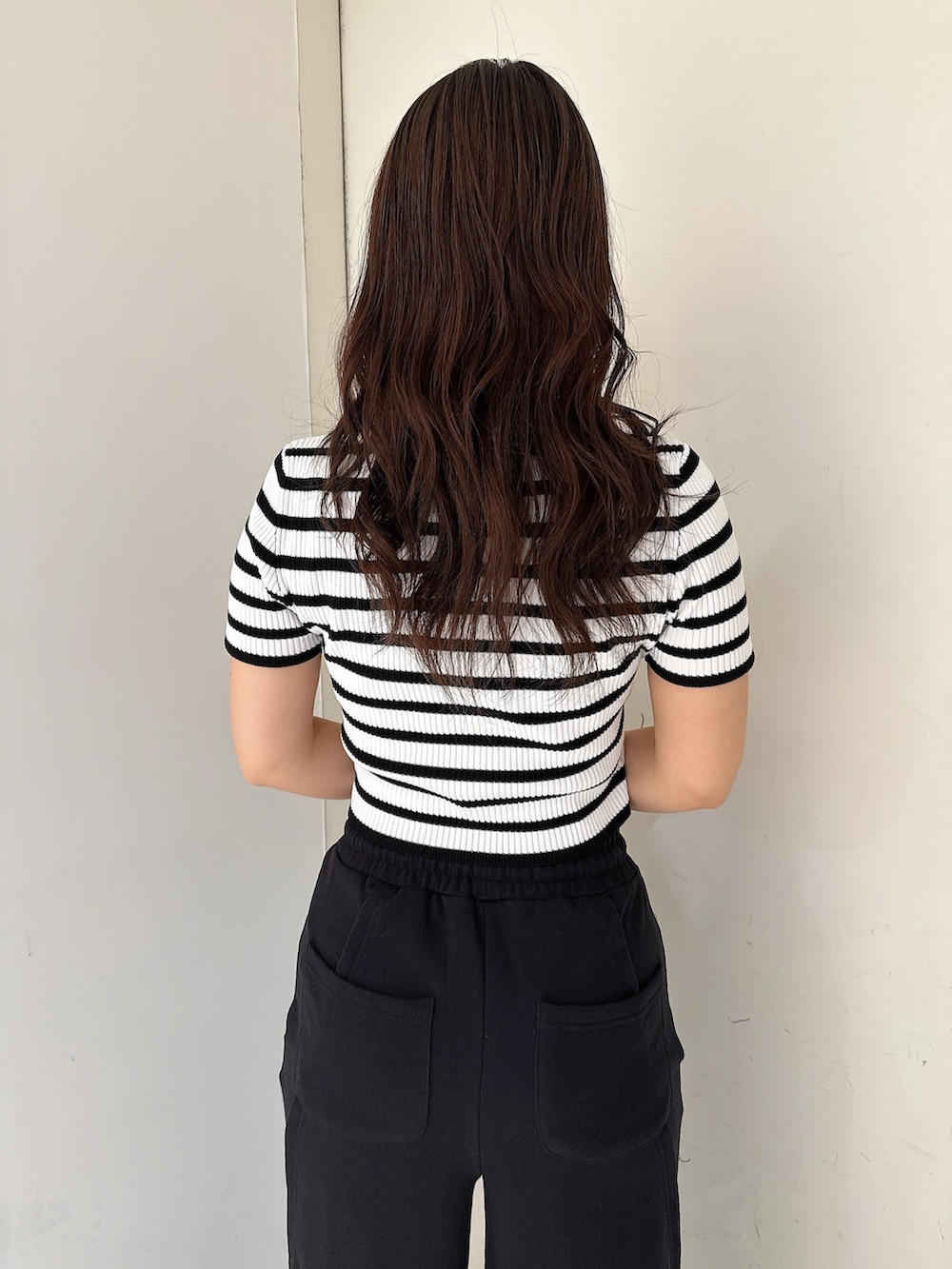 ブラック系のスウェットパンツ、ホワイト系のスニーカー、ブラック系のニット/セーターを着用したレディースの春コーディネートの6枚目の写真