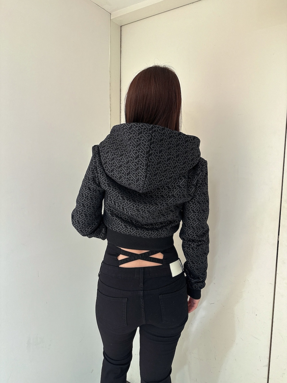 ブラック系のデニムパンツ、ブラック系のパーカー、ブラック系のブーツを着用したレディースの冬コーディネートの6枚目の写真