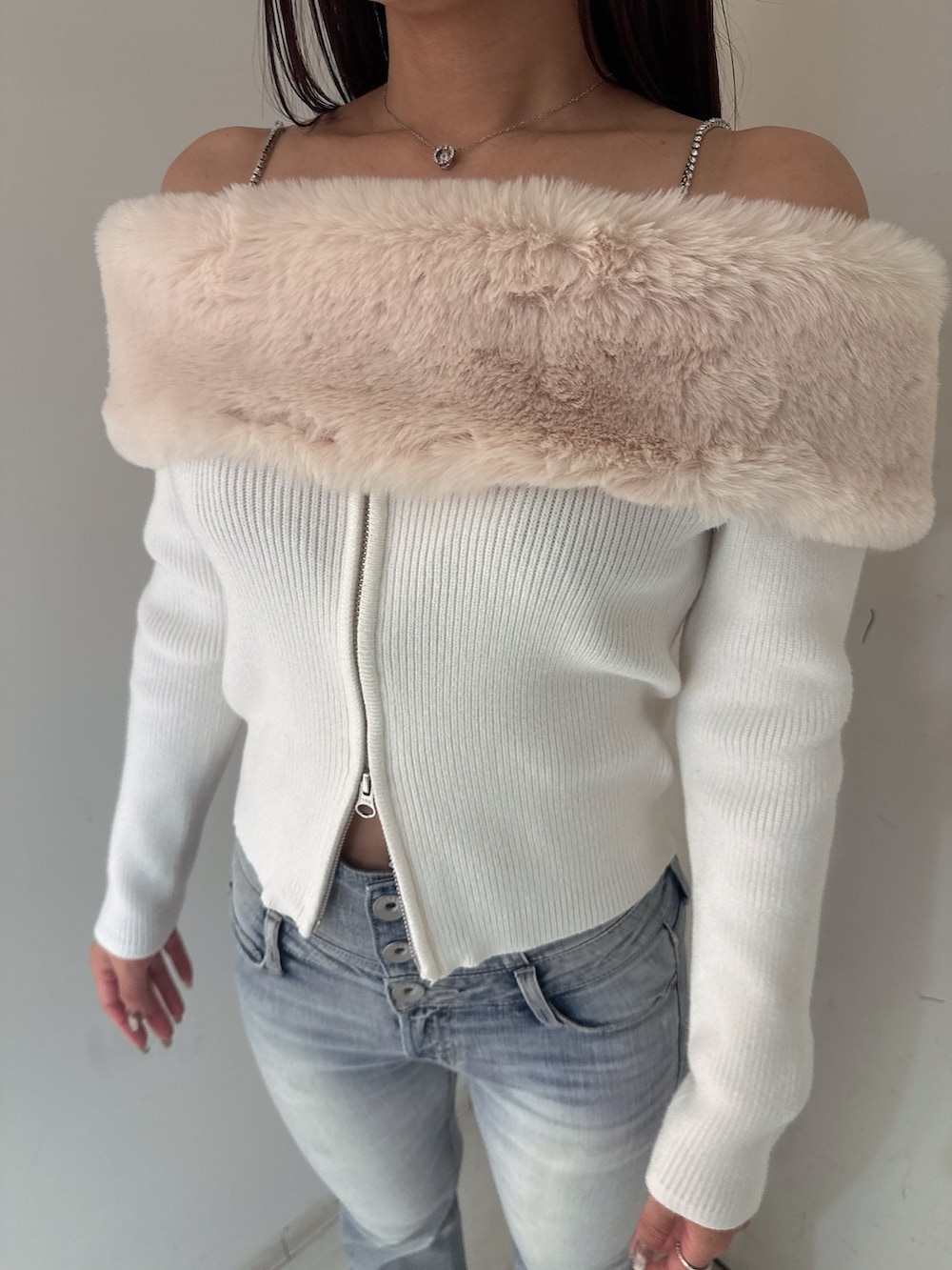 ホワイト系のニット/セーター、ブルー系のデニムパンツ、ブラック系のブーツを着用したレディースの秋コーディネートの7枚目の写真