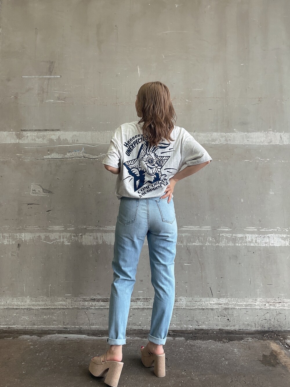 ブルー系のデニムパンツ、ホワイト系のサンダル、グレー系のTシャツ/カットソーを着用したレディースの夏コーディネートの3枚目の写真