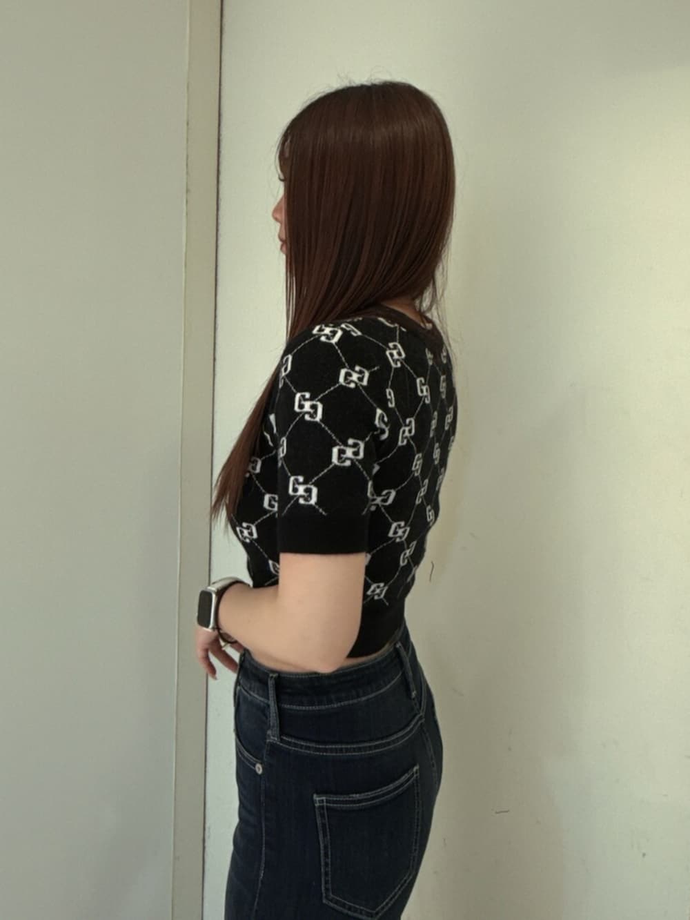ブルー系のデニムパンツ、ブラック系のニット/セーター、ブラック系のサンダルを着用したレディースの春コーディネートの5枚目の写真