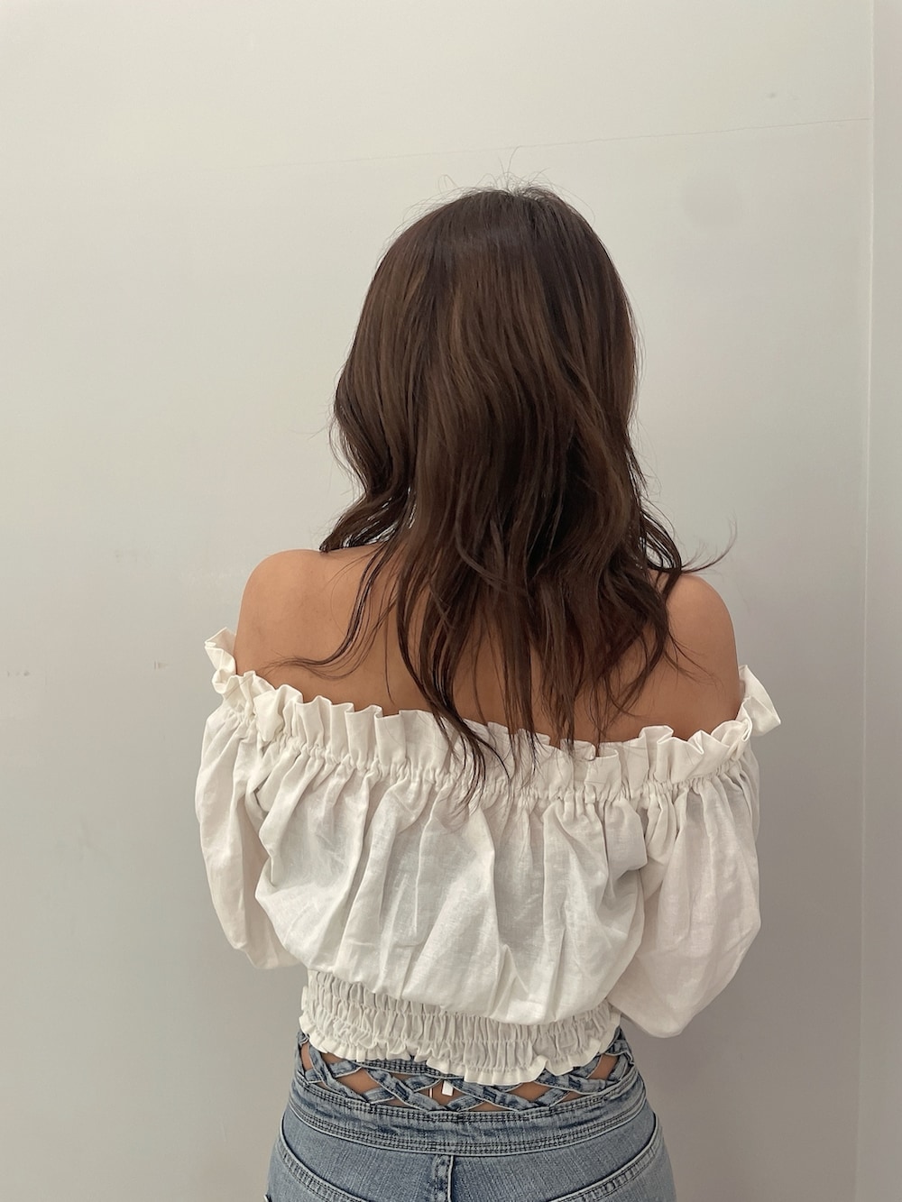 ホワイト系のシャツ/ブラウス、ホワイト系のサンダル、ブルー系のデニムパンツを着用したレディースの春コーディネートの7枚目の写真