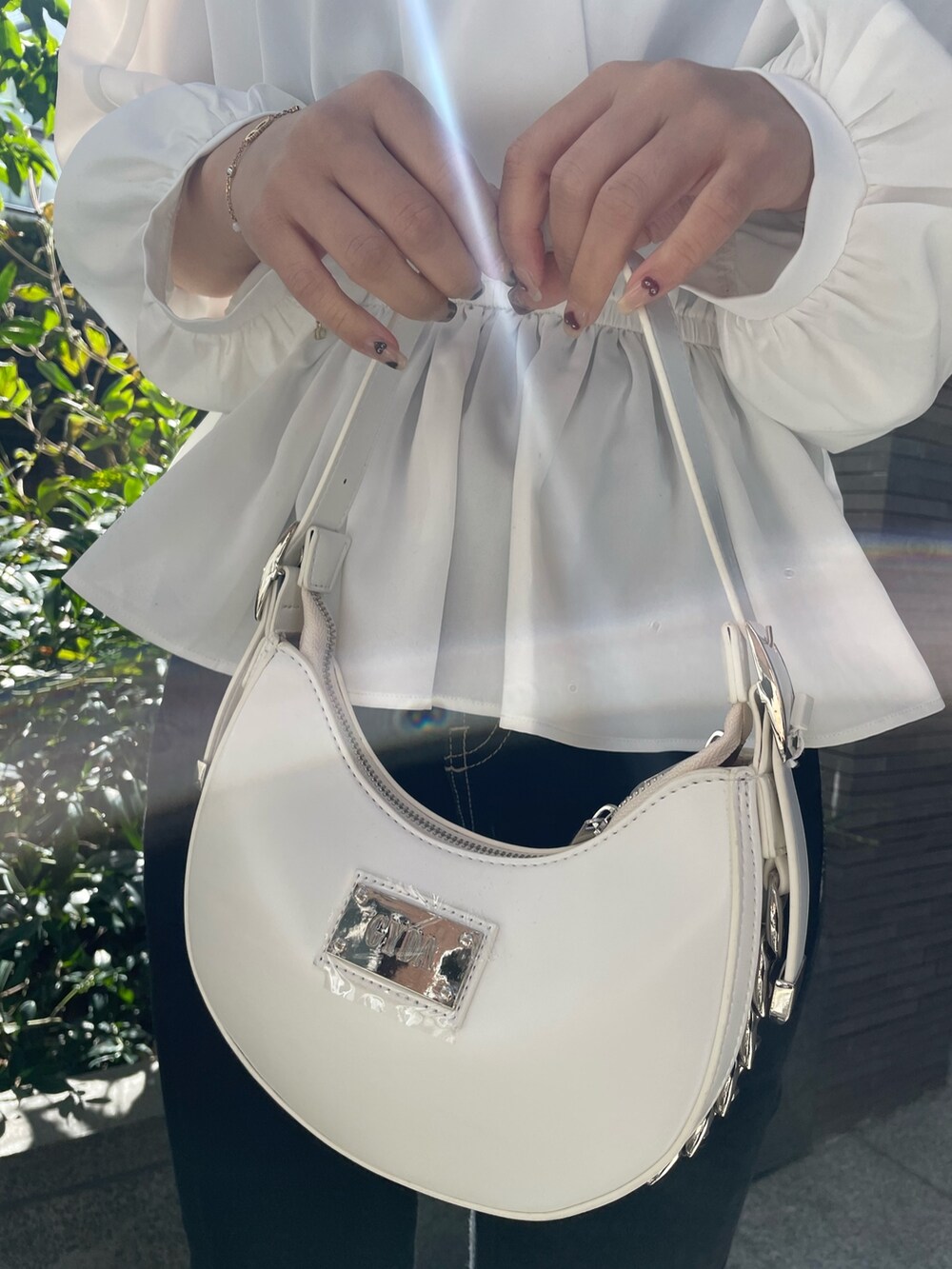 ブラック系のキャミソール、ホワイト系のシャツ/ブラウス、ホワイト系のハンドバッグを着用したレディースの冬コーディネートの6枚目の写真