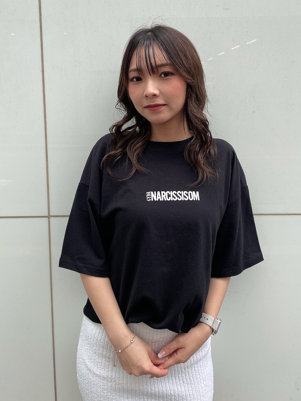 ブラック系のTシャツ/カットソー、ホワイト系のスカート、ホワイト系のサンダルを着用したレディースの春コーディネートの3枚目の写真