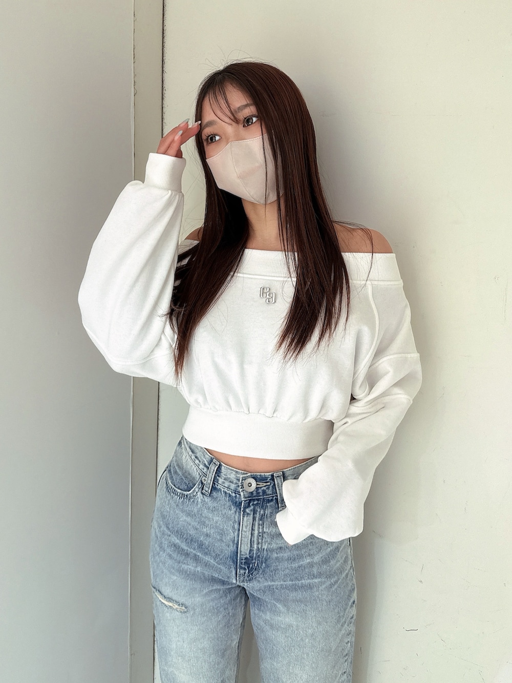 ホワイト系のスウェット、ブルー系のデニムパンツ、ホワイト系のサンダルを着用したレディースの冬コーディネートの4枚目の写真