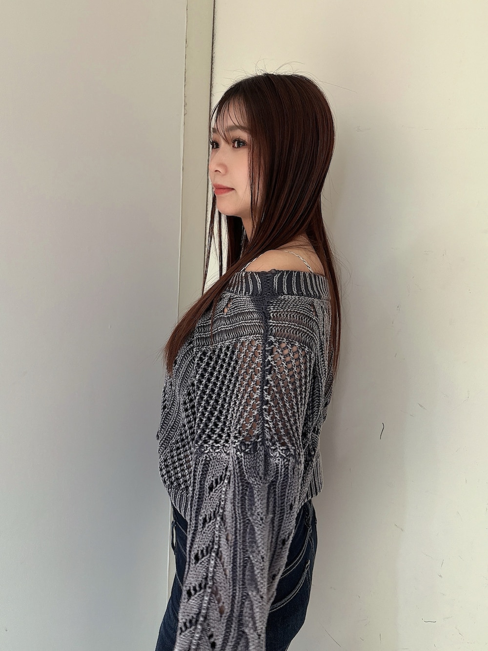 ブルー系のデニムパンツ、ブルー系のニット/セーター、ブラック系のサンダルを着用したレディースの春コーディネートの5枚目の写真