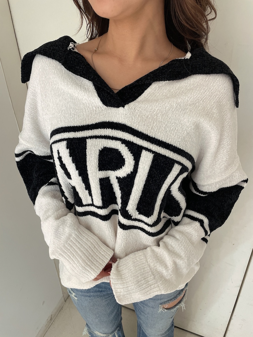 ホワイト系のニット/セーター、ブルー系のデニムパンツ、ホワイト系のパンプスを着用したレディースの秋コーディネートの7枚目の写真