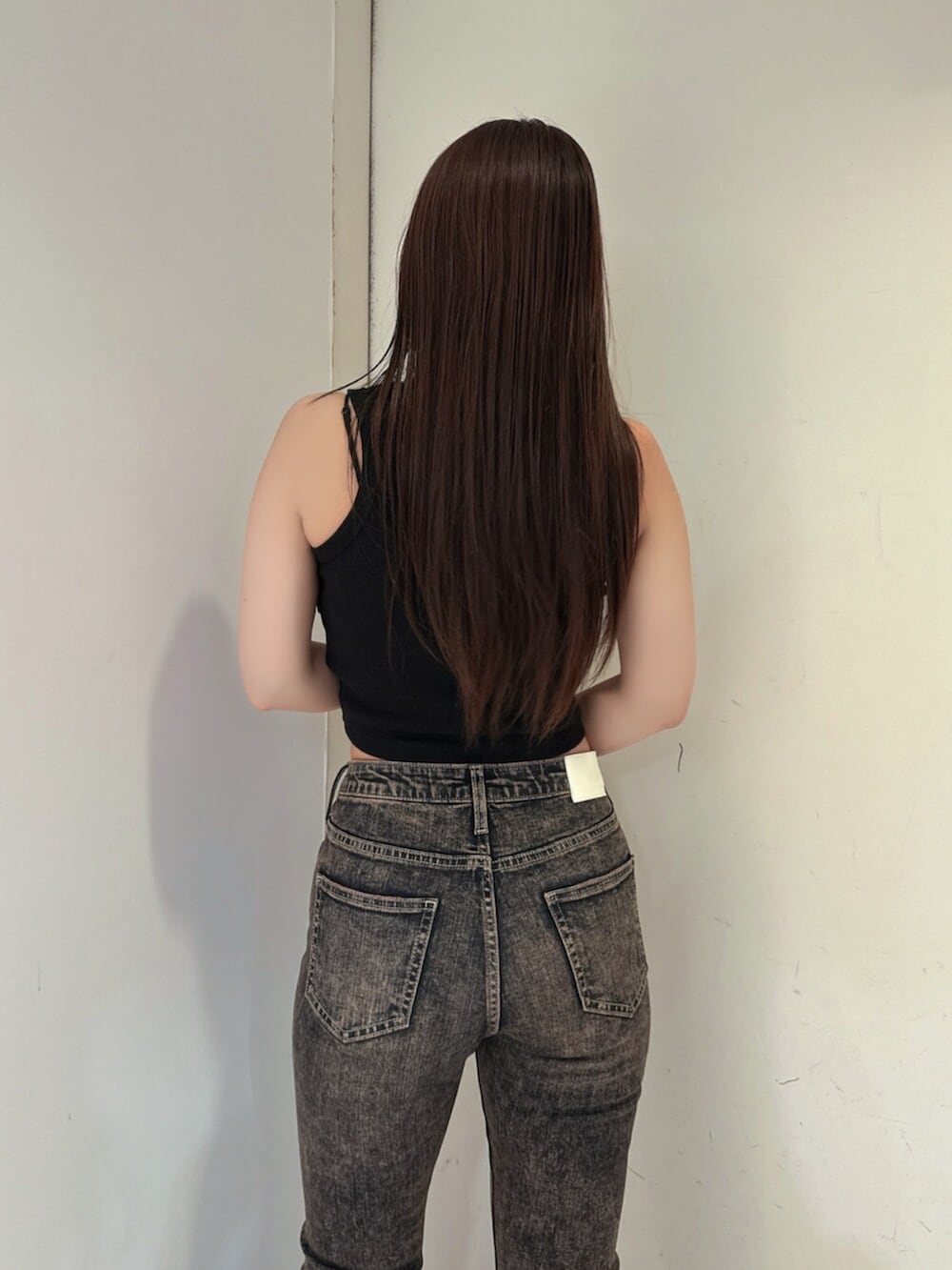 ブラック系のサンダル、ブルー系のデニムパンツ、ブラック系のタンクトップを着用したレディースの夏コーディネートの6枚目の写真