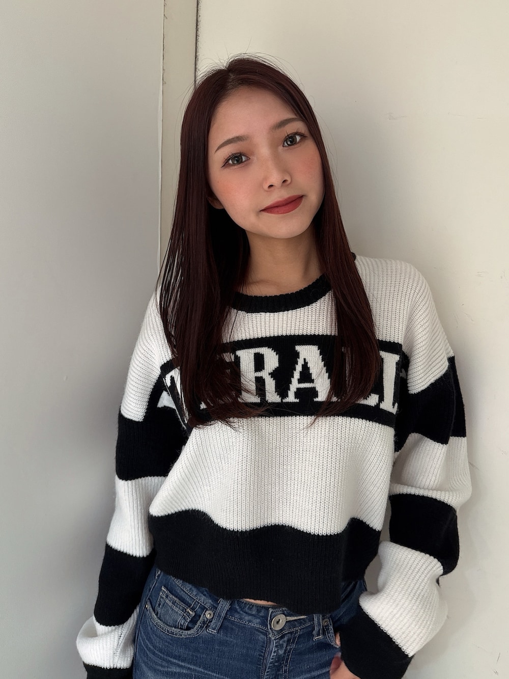 ブルー系のデニムパンツ、ブラック系のブーツ、ブラック系のニット/セーターを着用したレディースの秋コーディネートの4枚目の写真