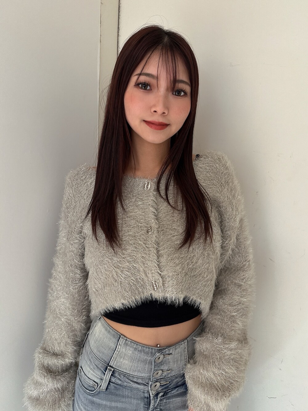 ブルー系のデニムパンツ、ホワイト系のパンプス、ベージュ系のカーディガン/ボレロを着用したレディースの秋コーディネートの4枚目の写真