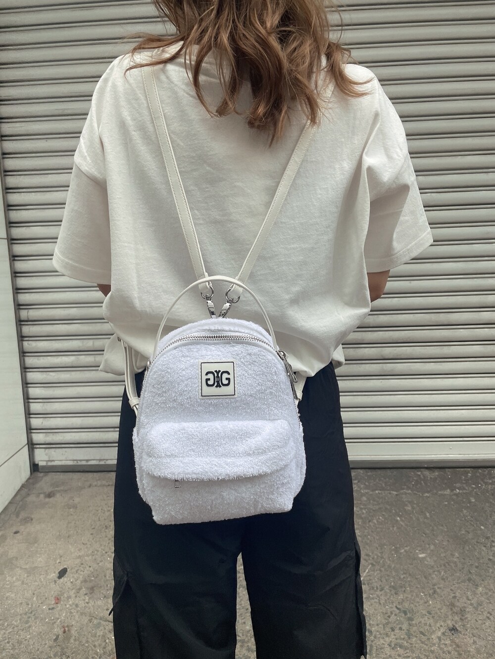 ホワイト系のバックパック/リュック、ホワイト系のTシャツ/カットソー、ブラック系のカーゴパンツを着用したレディースの夏コーディネートの6枚目の写真