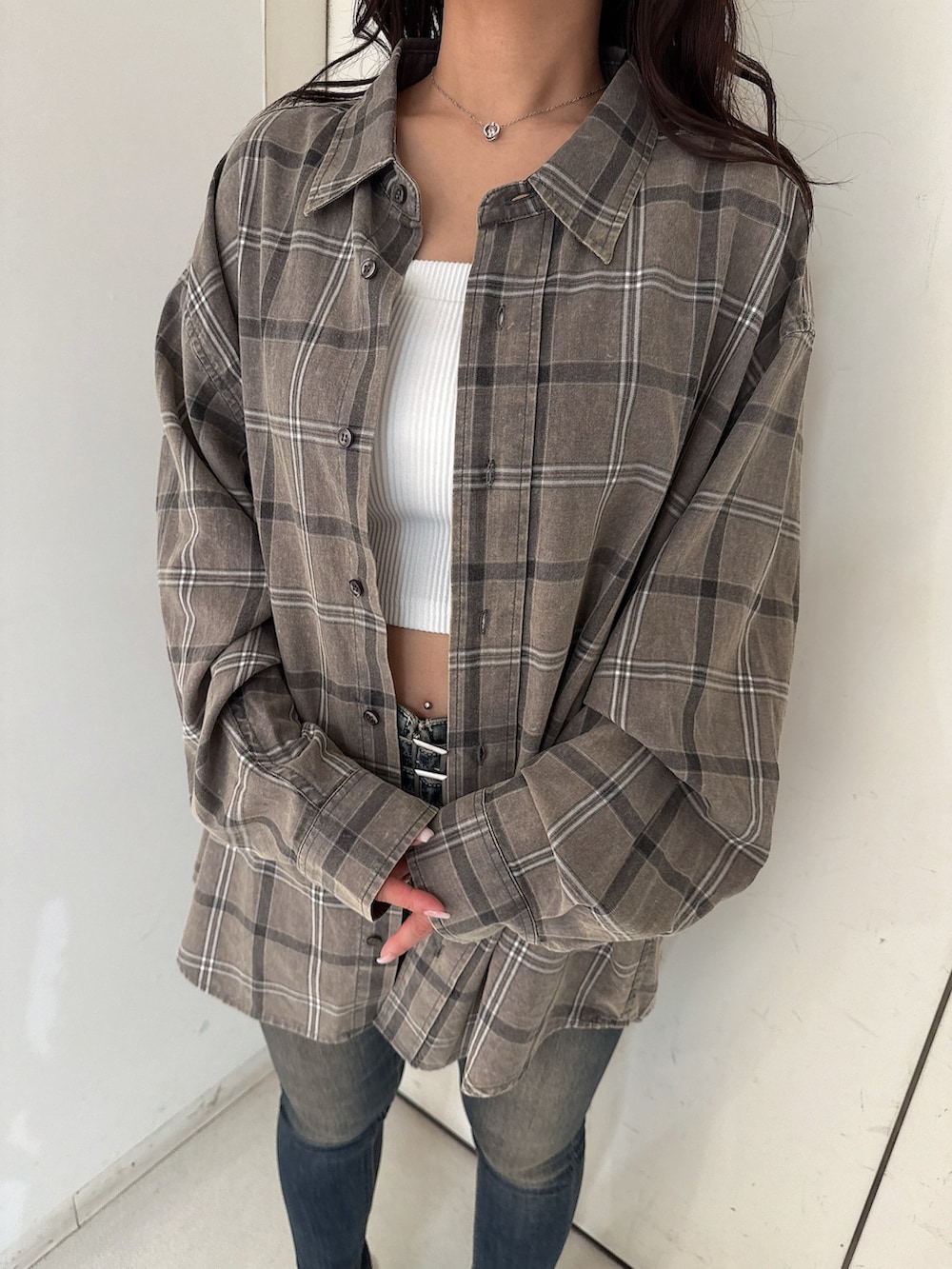 ホワイト系のキャミソール、グレー系のシャツ/ブラウス、ブルー系のデニムパンツを着用したレディースの春コーディネートの7枚目の写真