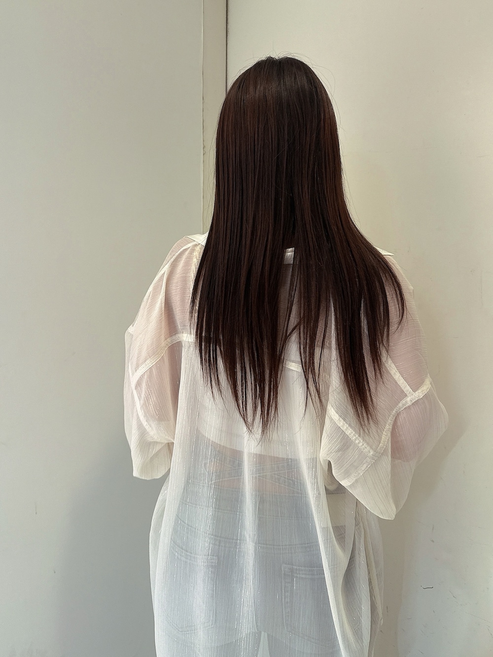 ブルー系のデニムパンツ、ホワイト系のチューブトップ、ホワイト系のシャツ/ブラウスを着用したレディースの春コーディネートの6枚目の写真