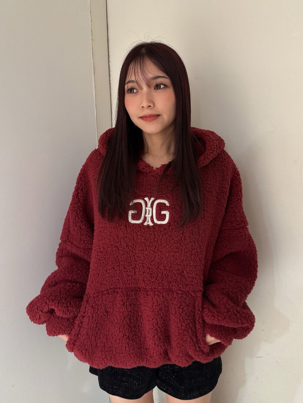 ブラック系のブーツ、レッド系のパーカー、ブラック系のその他パンツを着用したレディースの秋コーディネートの4枚目の写真