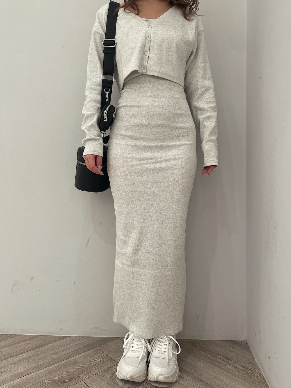 グレー系のワンピース、ブラック系のハンドバッグ、ホワイト系のスニーカーを着用したレディースの春コーディネートの7枚目の写真