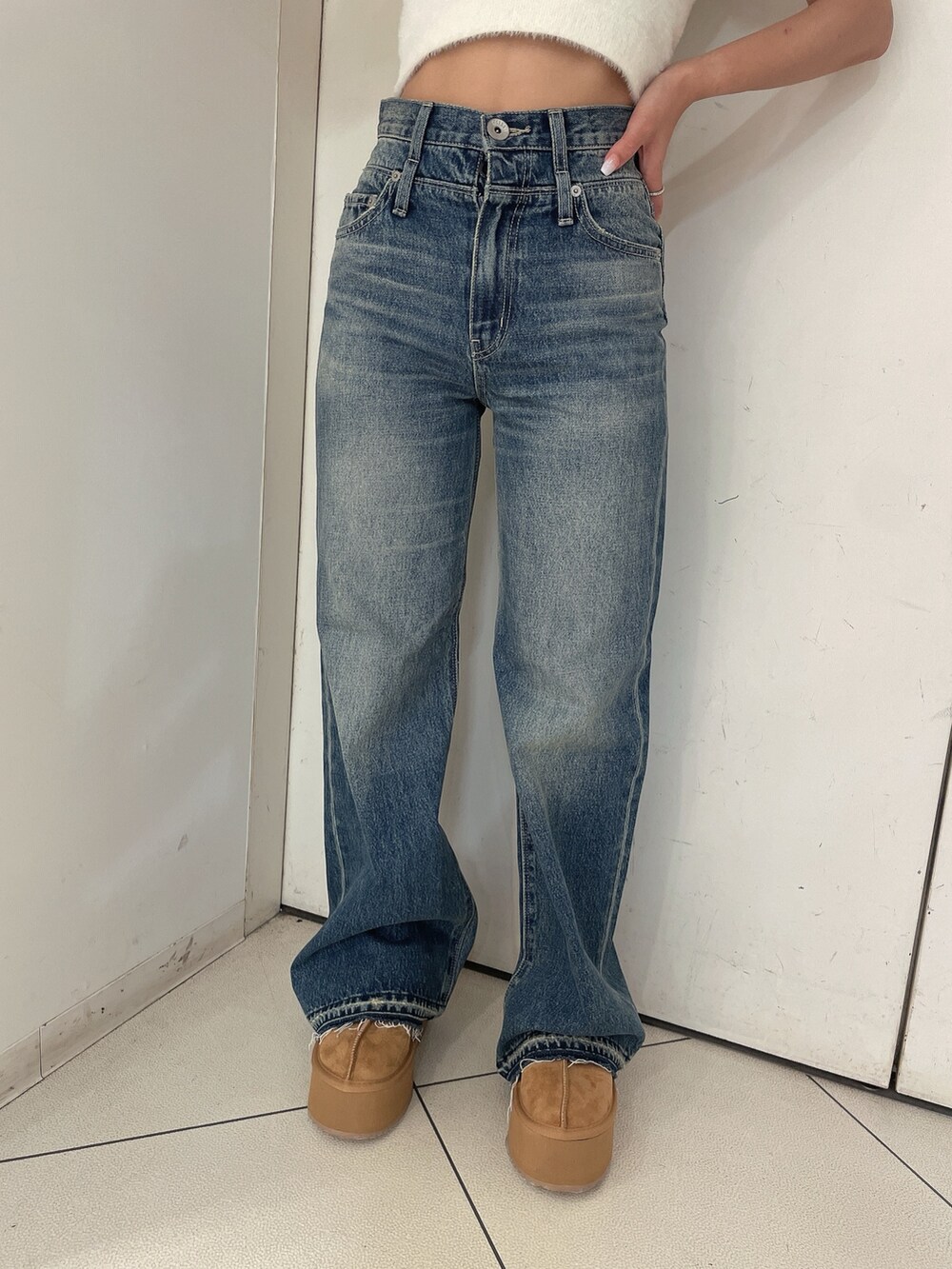 ホワイト系のニット/セーター、ブルー系のデニムパンツ、ベージュ系のスリッポンを着用したレディースの夏コーディネートの8枚目の写真