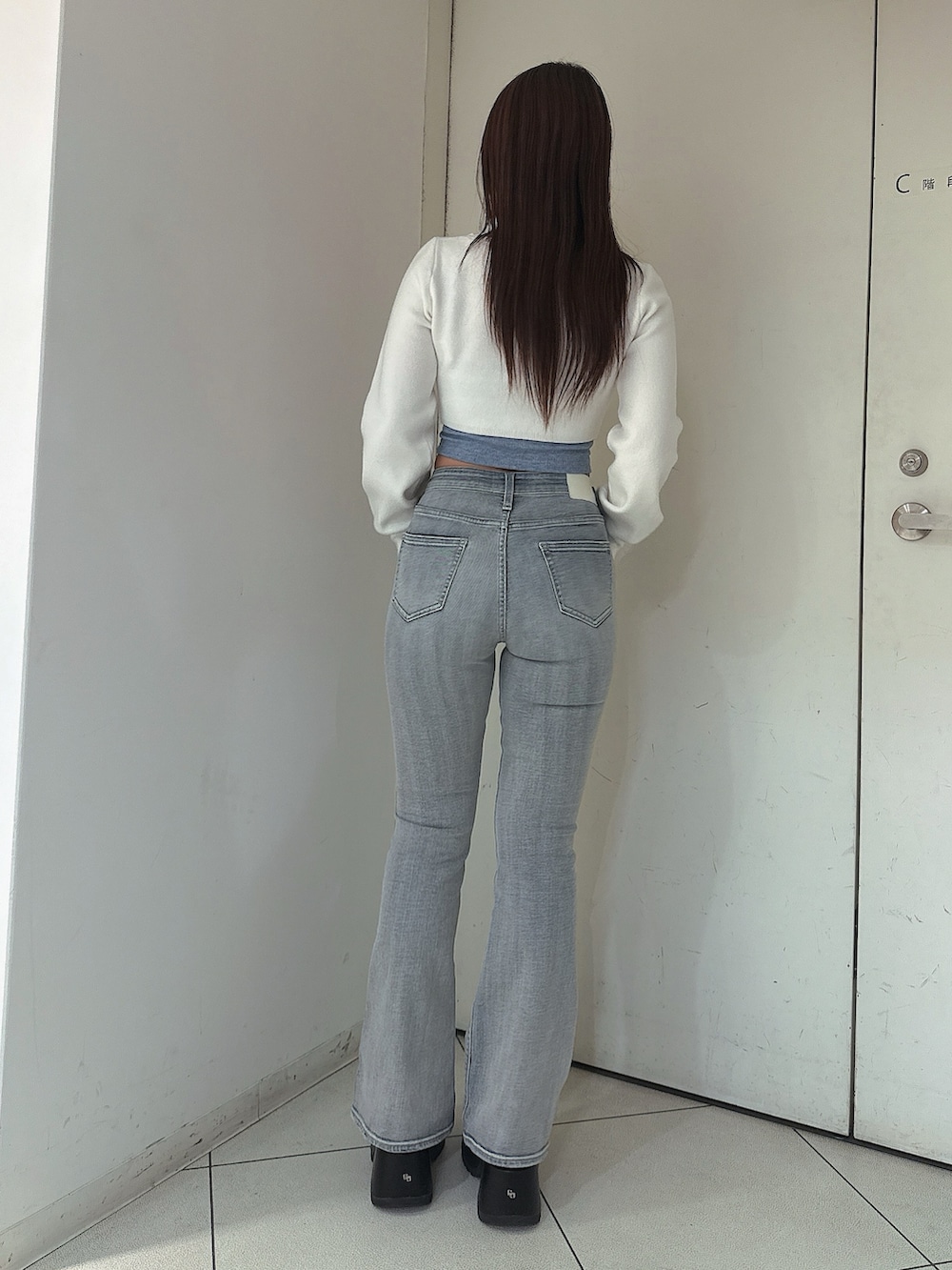 ブルー系のデニムパンツ、ブラック系のサンダル、ホワイト系のカーディガン/ボレロを着用したレディースの春コーディネートの3枚目の写真