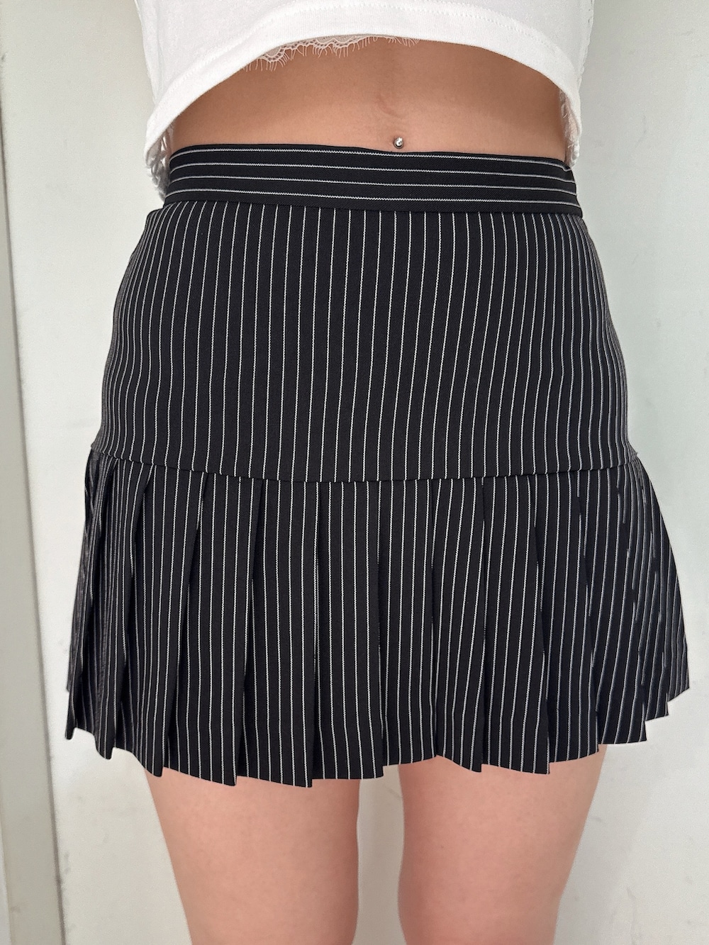 ブラック系のスカート、ホワイト系のタンクトップ、ブラック系のサンダルを着用したレディースの夏コーディネートの9枚目の写真