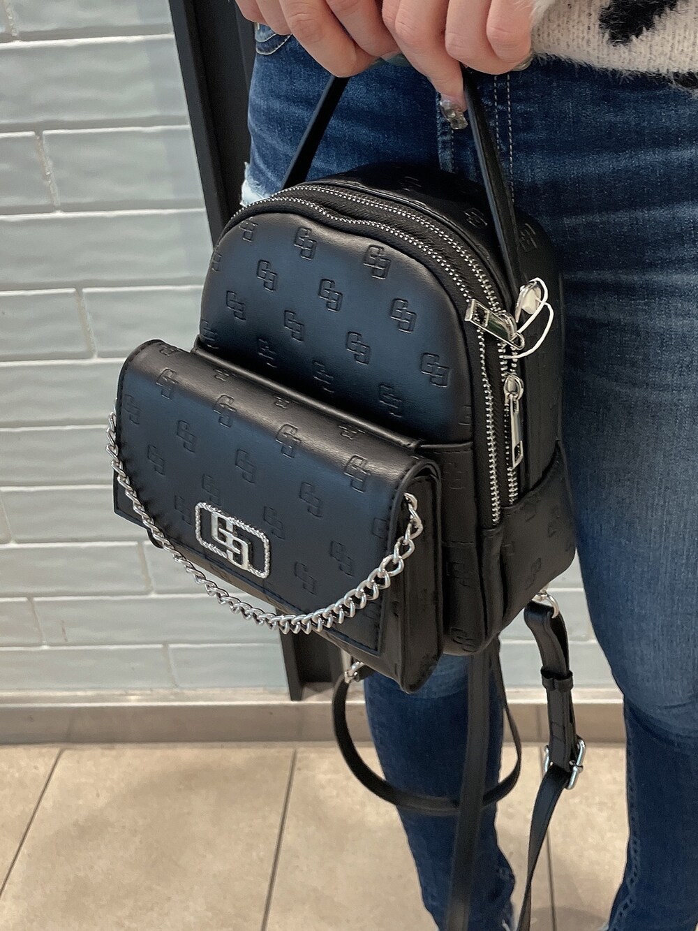 ホワイト系のニット/セーター、ブラック系のバックパック/リュック、ブラック系のパンプスを着用したレディースの冬コーディネートの8枚目の写真