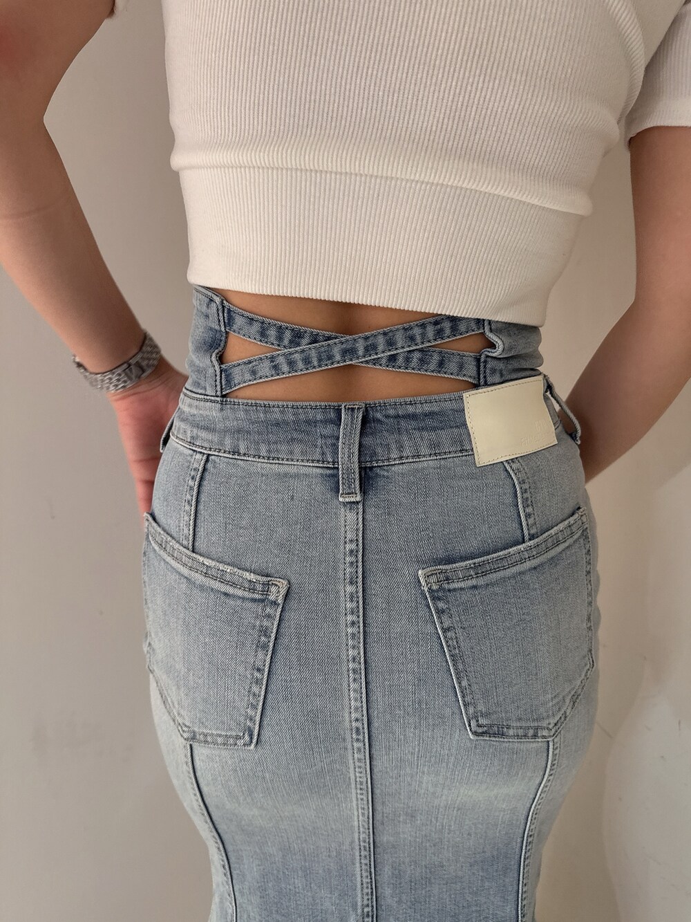ホワイト系のTシャツ/カットソー、ブルー系のデニムスカート、ホワイト系のサンダルを着用したレディースの夏コーディネートの9枚目の写真