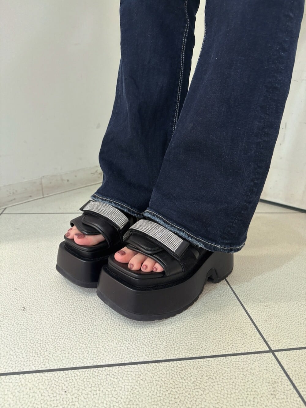 ブルー系のデニムパンツ、ブラック系のサンダル、ブラック系のニット/セーターを着用したレディースの春コーディネートの9枚目の写真