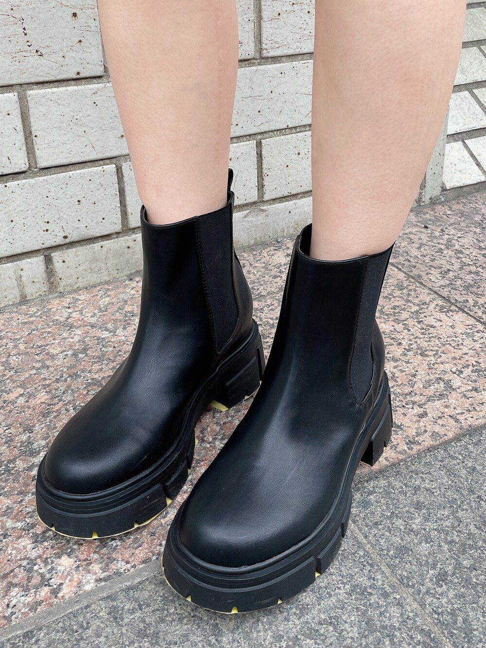 ブラック系のニット/セーター、ブルー系のデニムスカート、ブラック系のハンドバッグを着用したレディースの冬コーディネートの8枚目の写真
