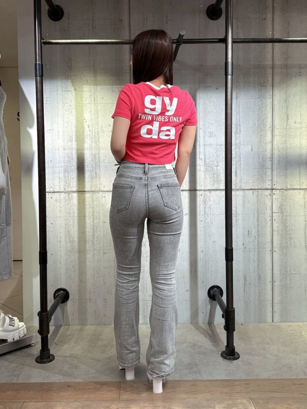 グレー系のデニムパンツ、ホワイト系のサンダル、ピンク系のTシャツ/カットソーを着用したレディースの夏コーディネートの3枚目の写真