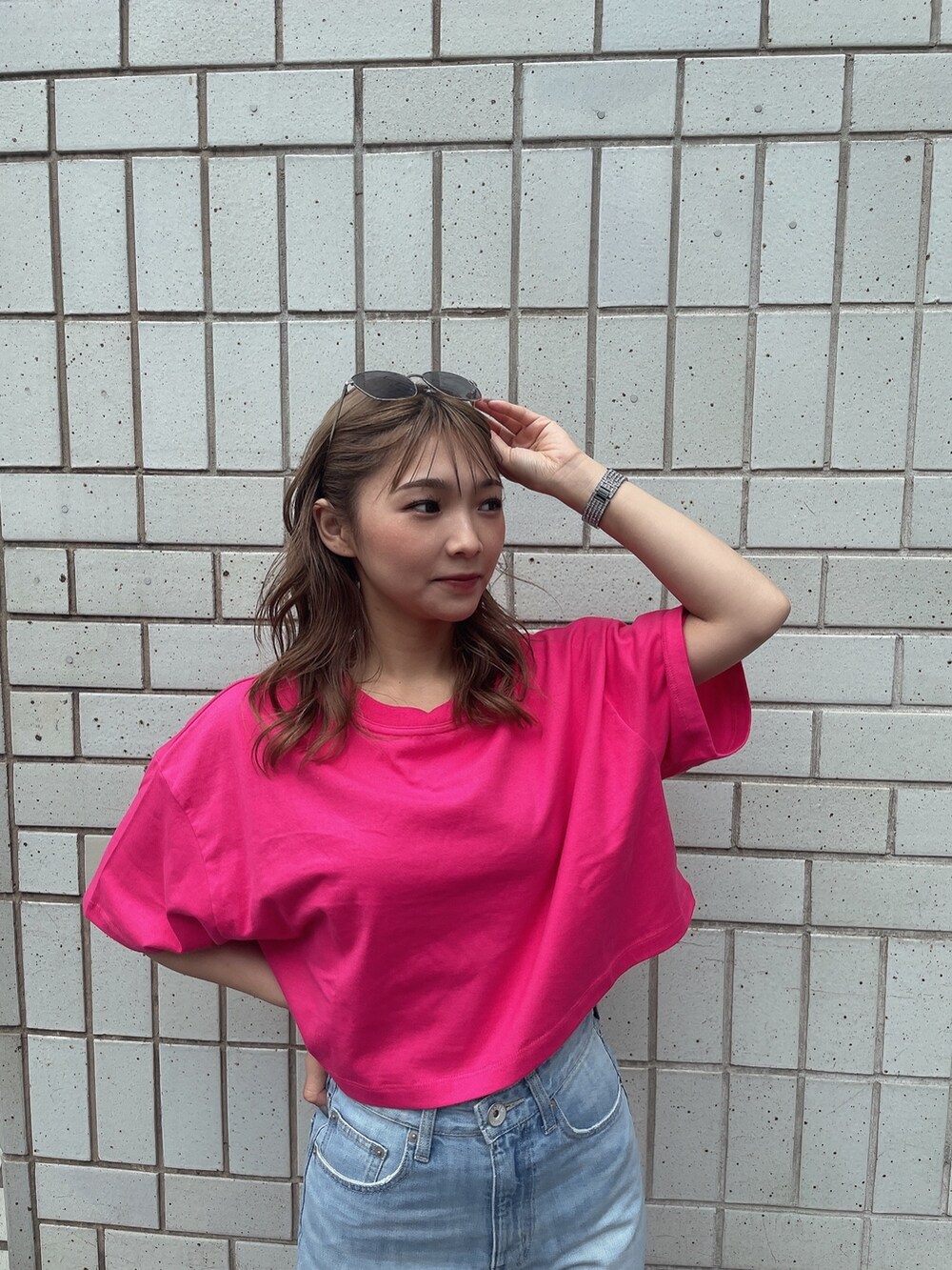 ブルー系のデニムパンツ、ホワイト系のサンダル、ピンク系のTシャツ/カットソーを着用したレディースの夏コーディネートの3枚目の写真