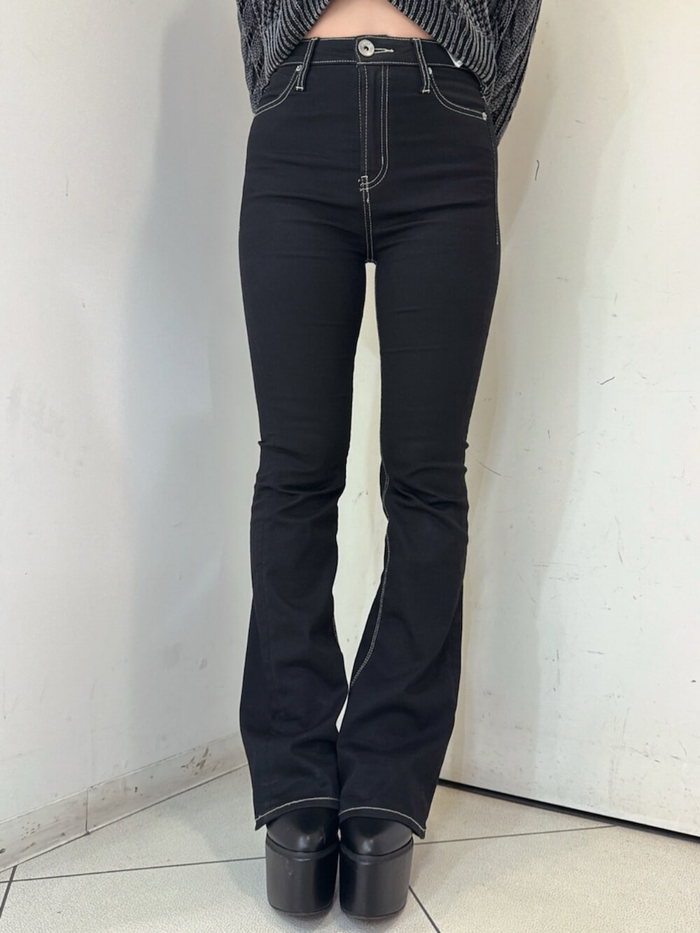 ブラック系のデニムパンツ、ブラック系のブーツ、ブラック系のニット/セーターを着用したレディースの夏コーディネートの8枚目の写真