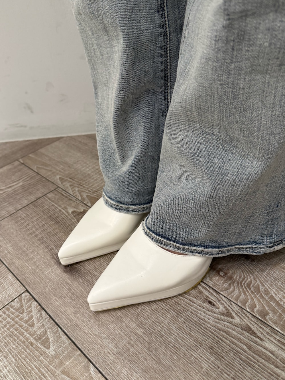 ホワイト系のブルゾン、ブラック系のニット/セーター、ブルー系のデニムパンツを着用したレディースの冬コーディネートの8枚目の写真