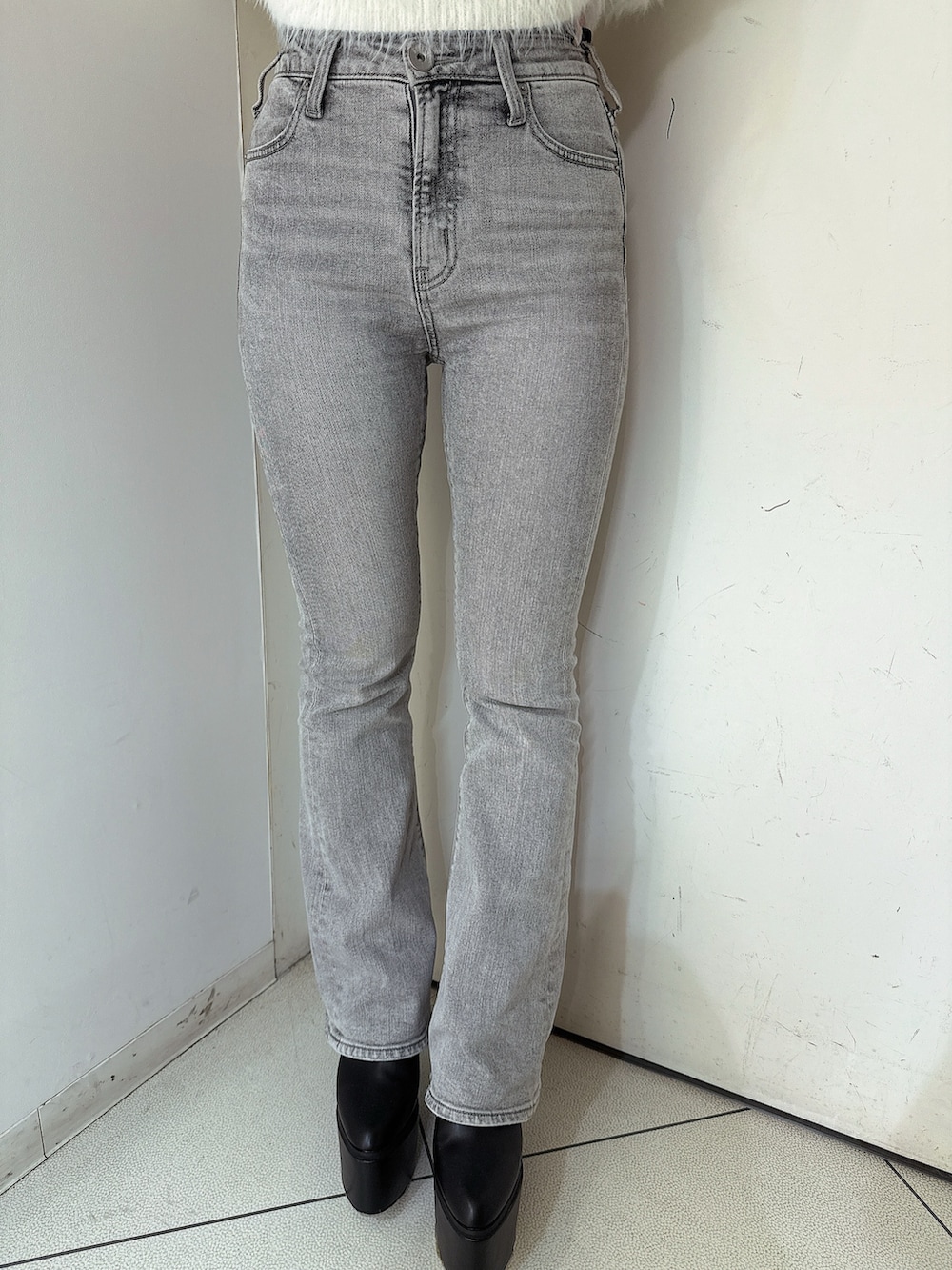 グレー系のデニムパンツ、ブラック系のブーツ、グレー系のニット/セーターを着用したレディースの冬コーディネートの7枚目の写真