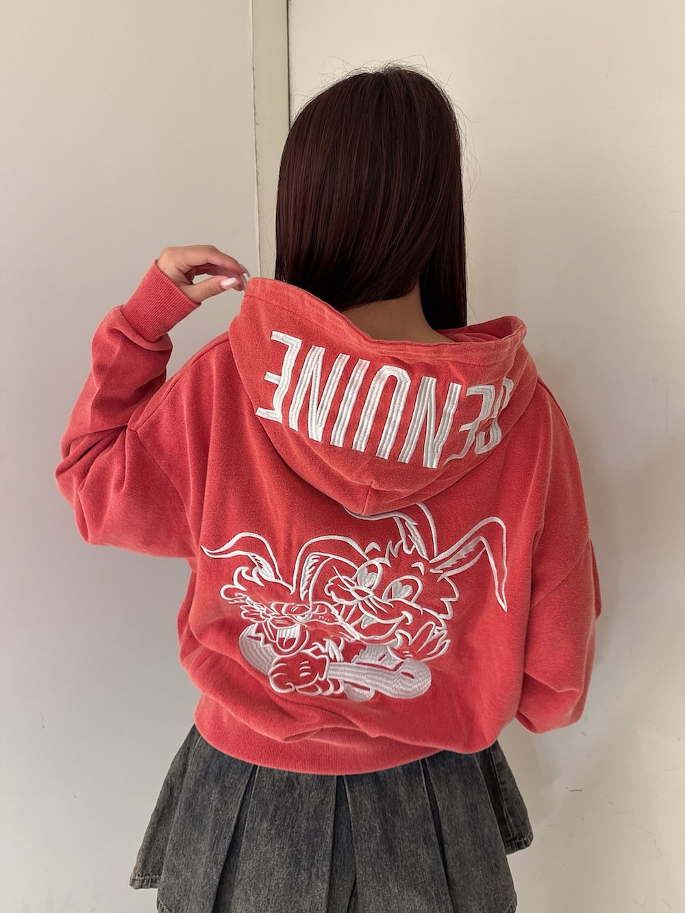 レッド系のパーカー、その他のデニムスカート、ブラック系のブーツを着用したレディースの秋コーディネートの6枚目の写真