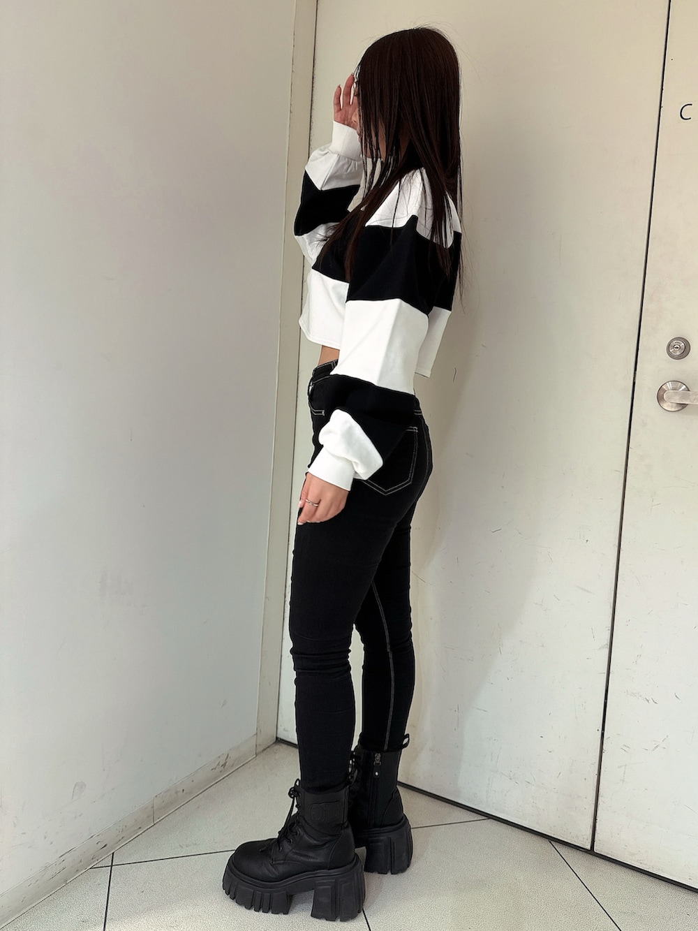 ブラック系のデニムパンツ、ブラック系のブーツ、ホワイト系のTシャツ/カットソーを着用したレディースの冬コーディネートの2枚目の写真