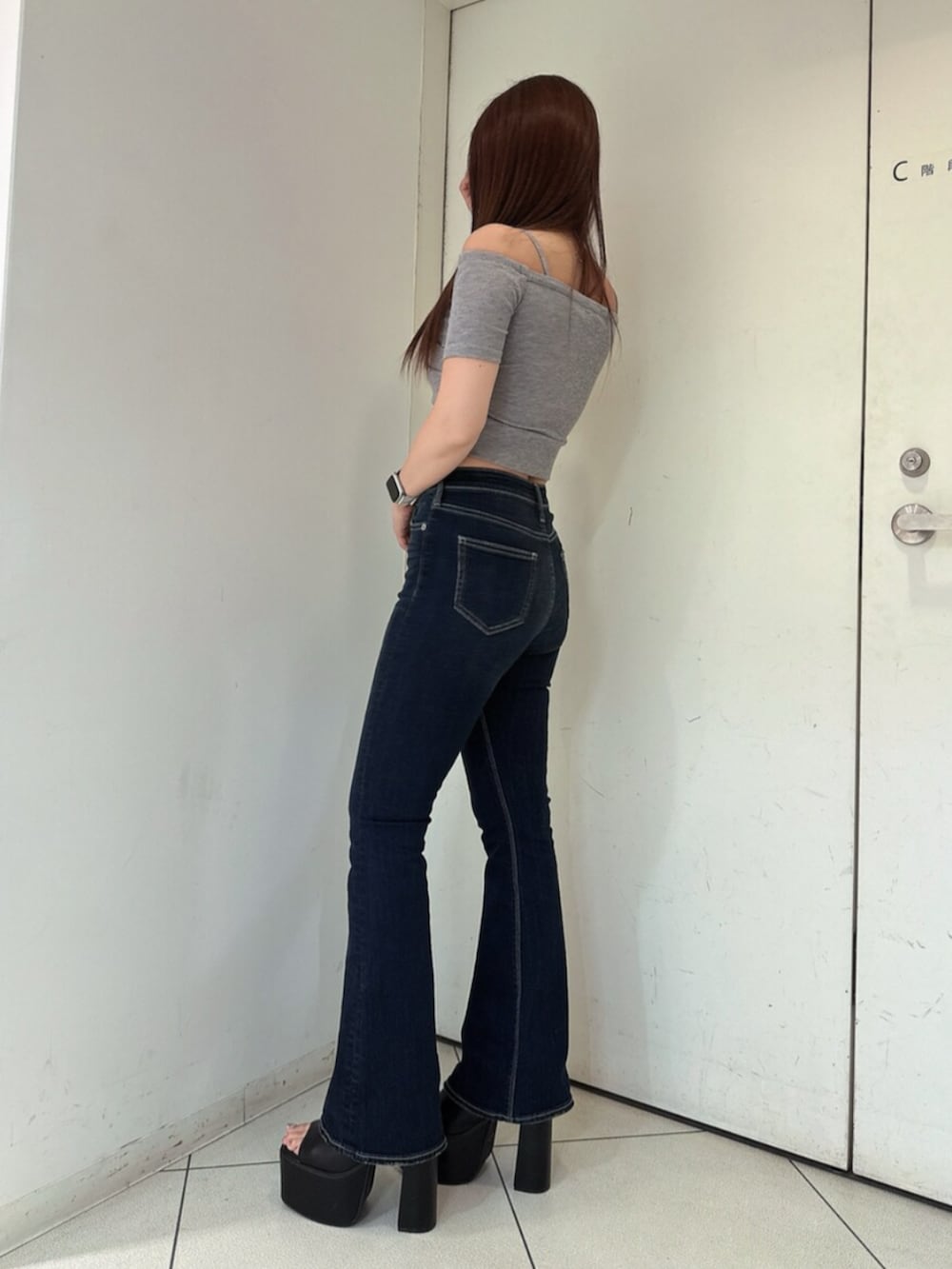 ブルー系のデニムパンツ、ブラック系のサンダル、グレー系のTシャツ/カットソーを着用したレディースの春コーディネートの2枚目の写真